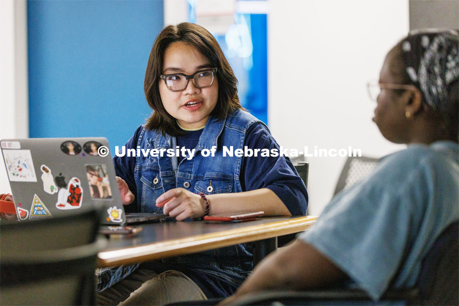 Thi Hoang Mai Vu, a CoJMC senior from Vietnam, talks with a student in the Jacht Ad Agency. She is featured for Asian and Pacific Islander Desi American Heritage Month. May 10, 2023. Photo by Craig Chandler / University Communication.